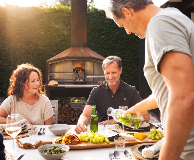 Gezin dat barbecue aan het eten is in de tuin